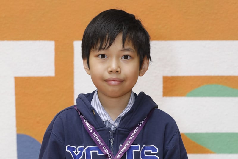 YCIS young mathematician holding a certificate and wearing a medal for mathematics without borders international tournament 
