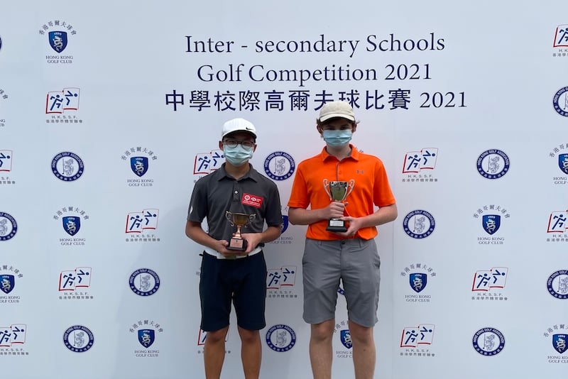 YCIS students both holding trophies from the Hong Kong Golf Association Tournament